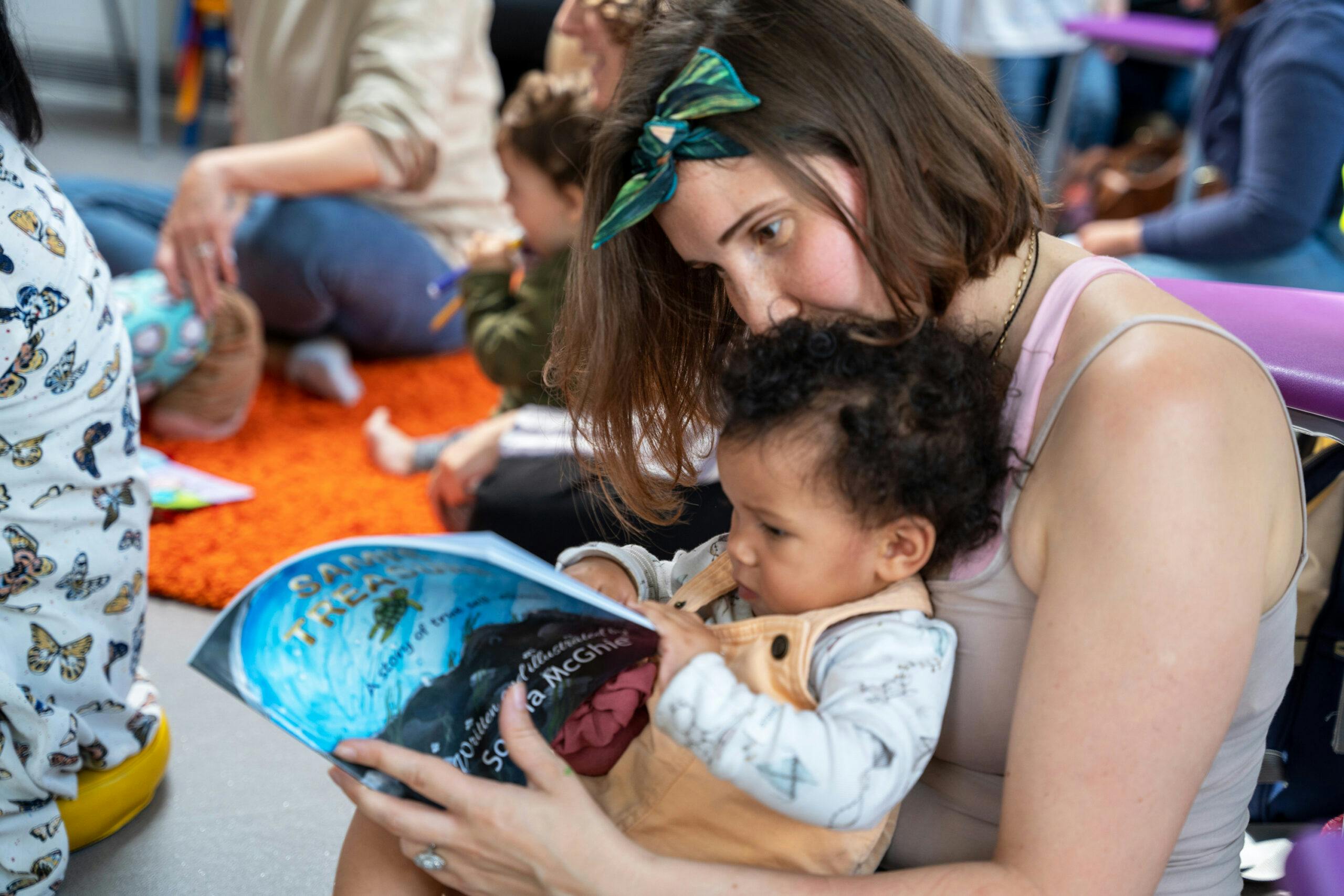 A mum reading to her baby at a LEAP REAL session