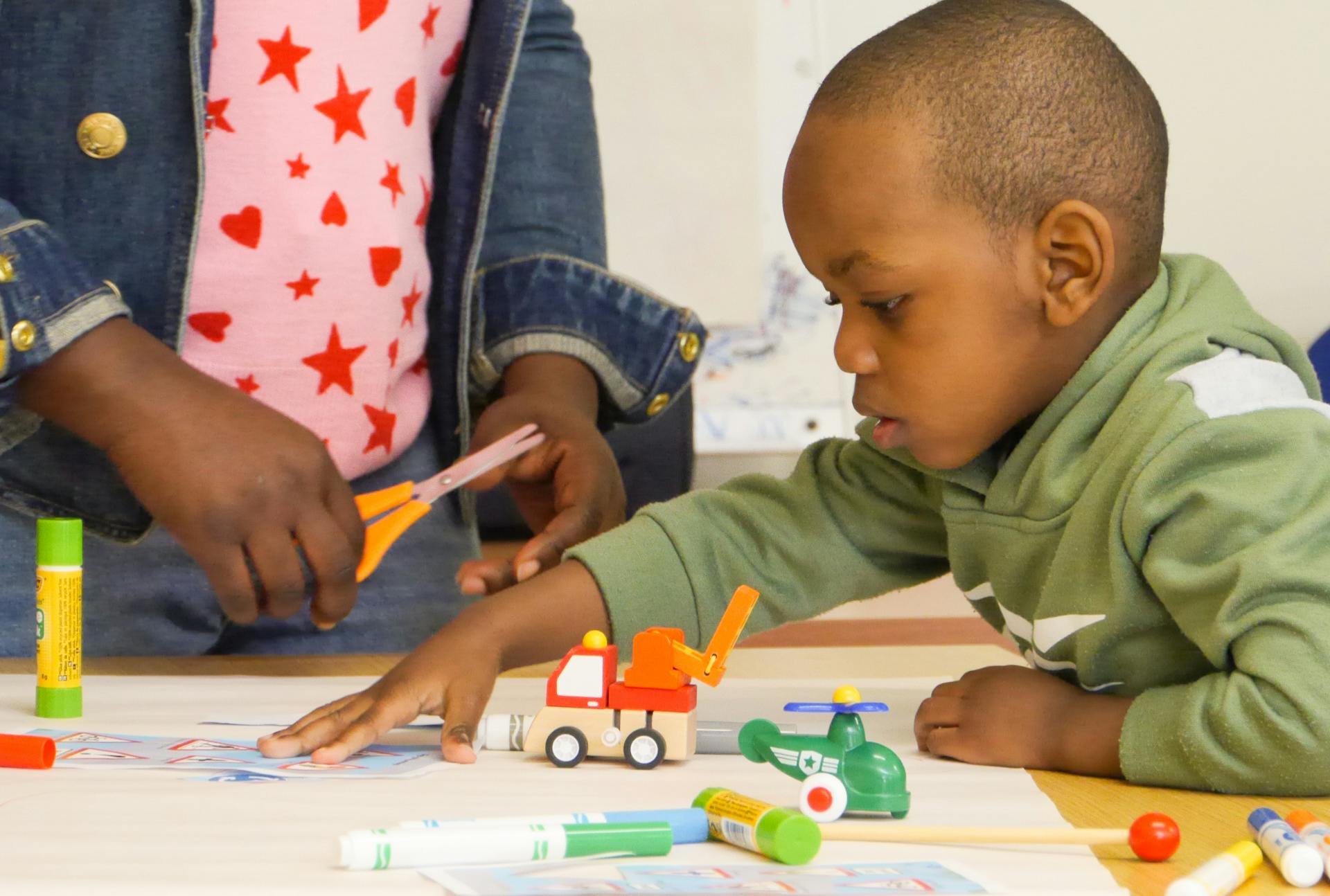 A young boy taking part in a LEAP session focussing on communication and language development. He is using colouring pens and making marks.