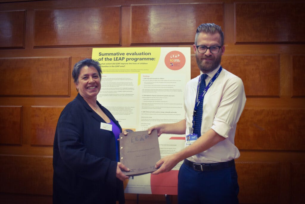 NCB Chief Executive, Anna Feuchtwang holding a ceremonial book of LEAP's 10 years at LEAP's learning event: 10 years of LEAP