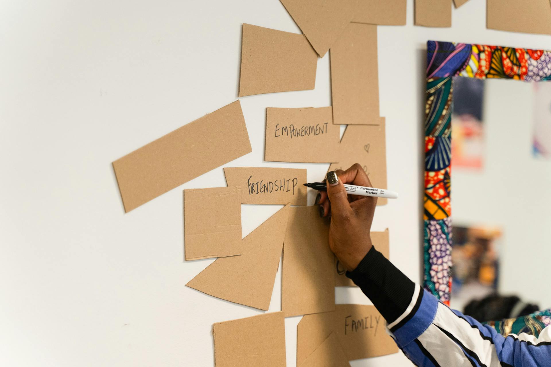 A parent writing friendship during a feedback exercise at the LEAP and Me exhibition.